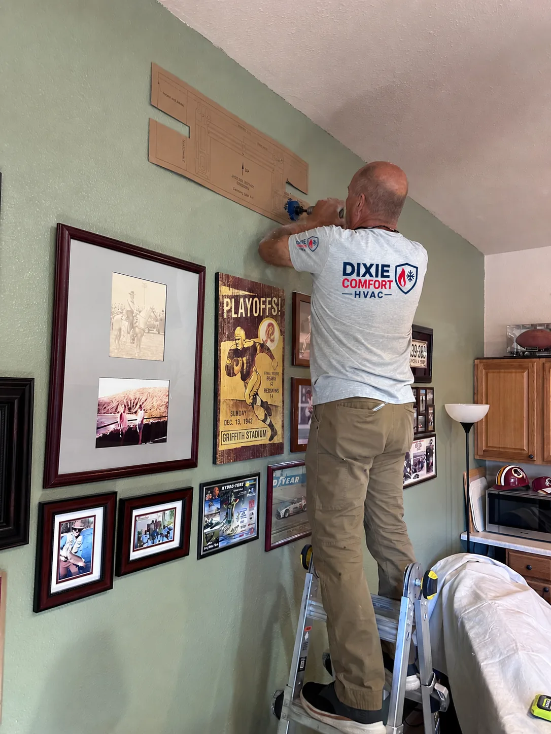 Bret Bergstrom of Dixie Comfort HVAC drilling the mounting plate for a mini-split indoor head in a Duck Creek cabin