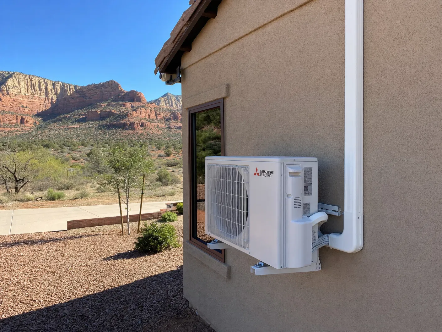 Mini-split condenser unit installed on St. George, Utah home with red rock landscape in background
