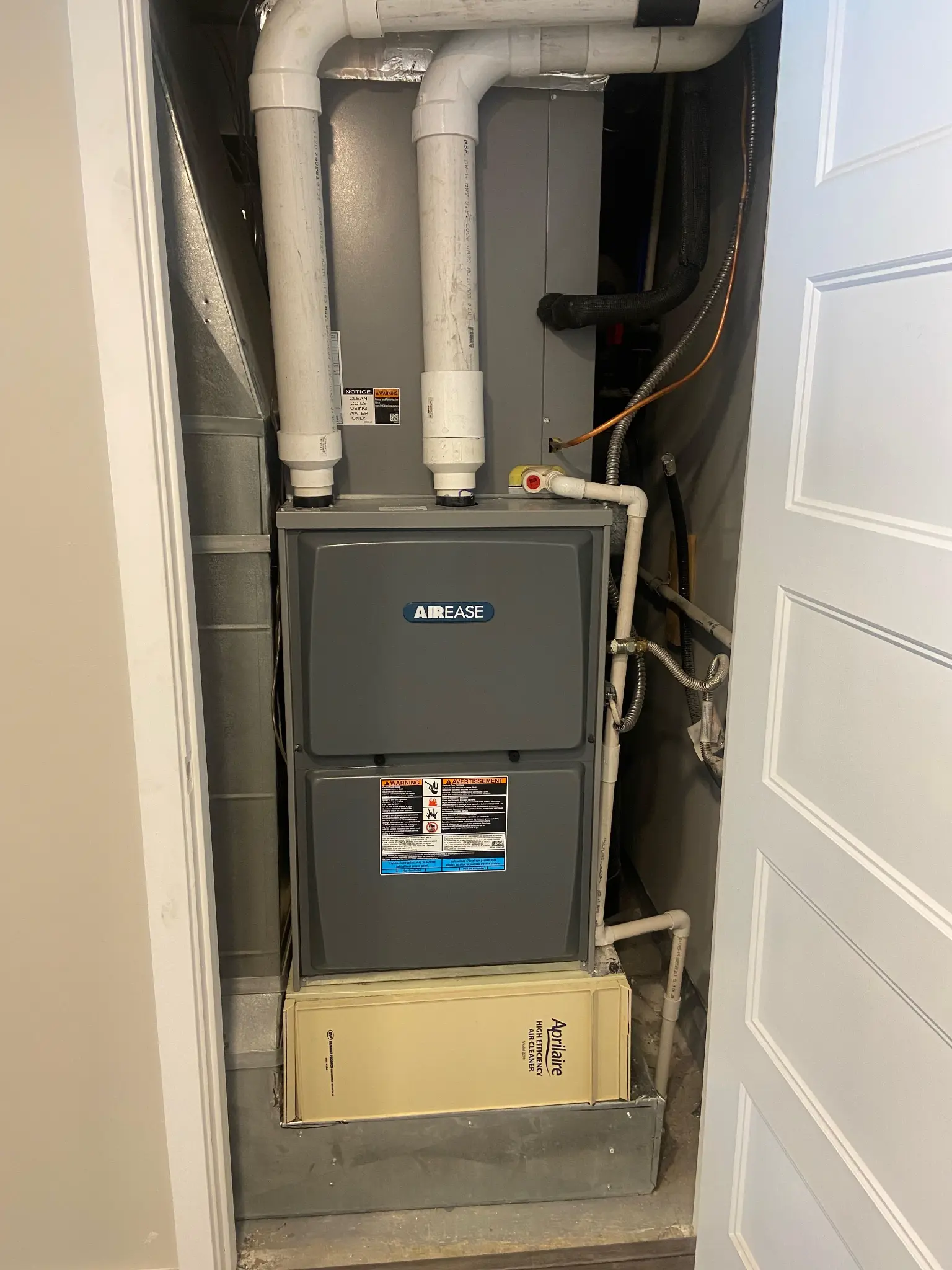 AirEase high-efficiency furnace installed in a hallway closet in St. George, Utah, with Aprilaire whole-home air cleaner and PVC venting in tight space